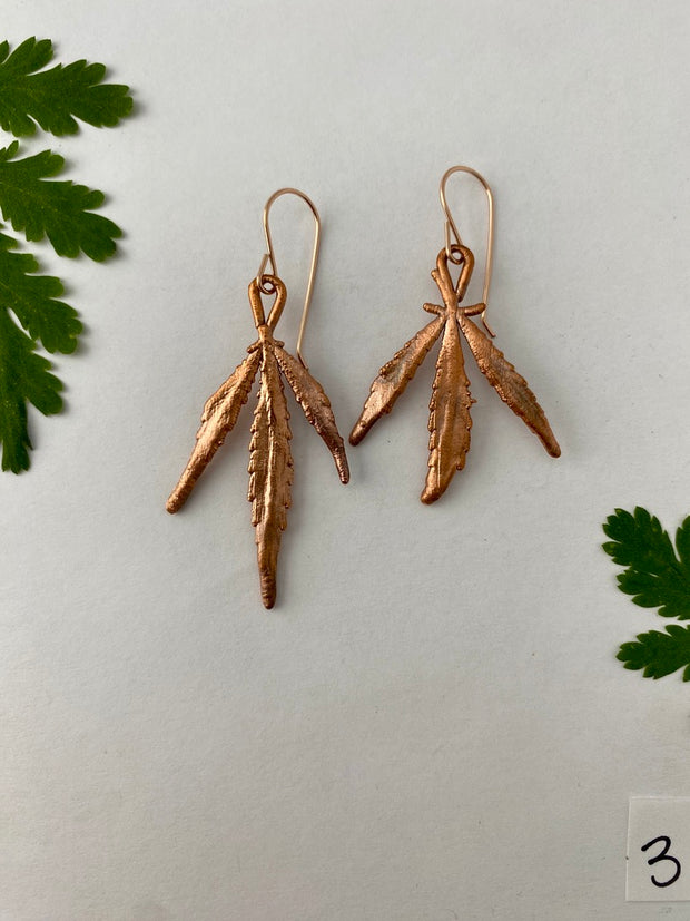 real cannabis leaf earrings electroplated with recycled copper 14 karat gold by simple wealth art made in usa